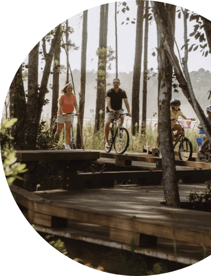 A family biking down one of the wooded trails in Wildlight.